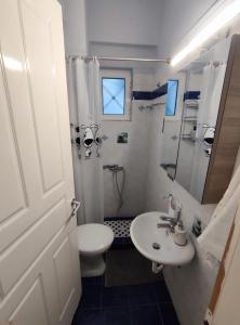 uma casa de banho com um lavatório, um WC e um chuveiro em George Central Apartment em Pirgos