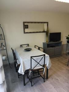 a dining room with a table with chairs and a television at La Goélette in Bazincourt-sur-Saulx