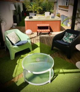 eine Terrasse mit 2 Stühlen, einem Tisch und einem Whirlpool in der Unterkunft Endroit Cosy in Angers