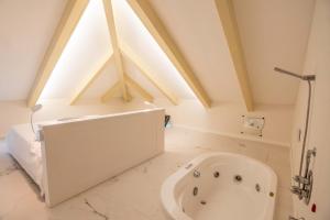 Habitación con baño con bañera blanca grande. en Villa Lara Hotel, en Amalfi