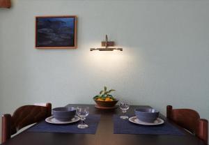 una mesa de comedor con 2 platos y copas de vino en Apartments Kuća Nebeska, en Viganj