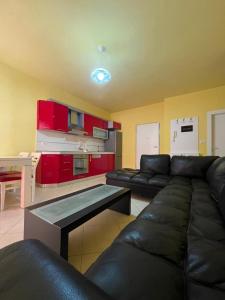 a living room with a black couch and red cabinets at Mineu Vacation Rentals in Golem