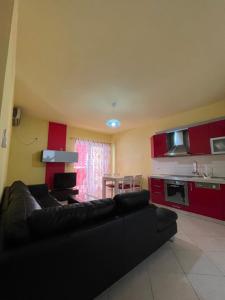 a living room with a black couch and a kitchen at Mineu Vacation Rentals in Golem