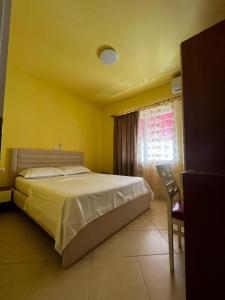 a bedroom with a bed and a chair and a window at Mineu Vacation Rentals in Golem