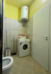 a bathroom with a washing machine and a toilet at Mineu Vacation Rentals in Golem