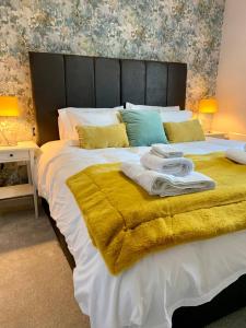 a bedroom with a large bed with towels on it at Domus, With free secure parking on site in York