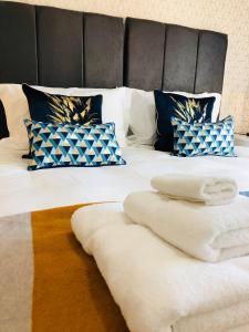 a bed with white towels and pillows on it at Domus, With free secure parking on site in York