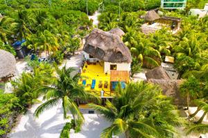 an overhead view of a yellow house on a beach with palm trees at Casa Luz Beach Front Holbox in Holbox Island