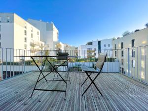 une table et deux chaises assises sur une terrasse dans l'établissement Appartements avec parking - Cite du Vin, à Bordeaux