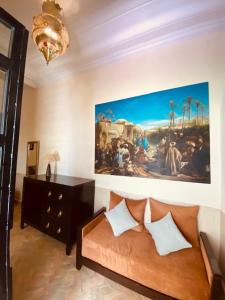 a living room with a couch and a painting on the wall at Riad Ajmal in Marrakech