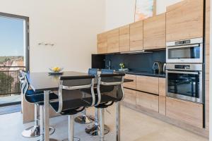 a kitchen with a table and some chairs in it at Regina's Banyuls - Modern and brand new apartment in Banyuls-sur-Mer