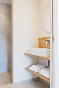 un bagno con lavandino e specchio di Regina's Banyuls - Modern and brand new apartment a Banyuls-sur-Mer
