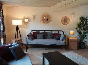 a living room with a couch and mirrors on the wall at Maison de village à Omerville in Omerville