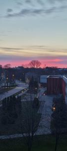 ein Sonnenuntergang über einer Stadt mit einem Parkplatz und Gebäuden in der Unterkunft Mājīgs studio apartaments jūras pilsētā in Ventspils