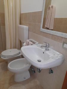 a bathroom with a white toilet and a sink at il Pascià Affittacamere in Otranto