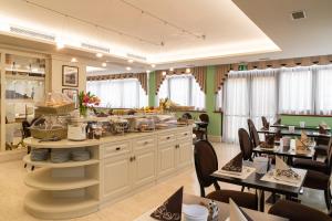 a restaurant with tables and chairs and a buffet at Hotel Roxy Plaza in Soave