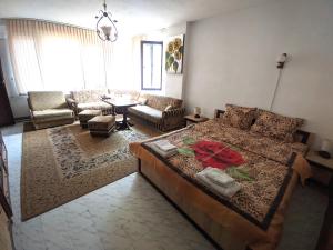 uma sala de estar com uma cama grande e um sofá em Guest House Perla em Bachkovo