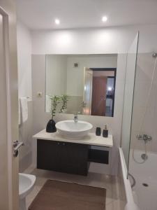 La salle de bains blanche est pourvue d'un lavabo et d'un miroir. dans l'établissement Magical Seaview (Free Parking), à Funchal