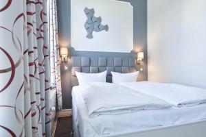 ein Schlafzimmer mit einem weißen Bett und einem Vorhang in der Unterkunft (61c) Villa Meeresblick 3 in Ahlbeck