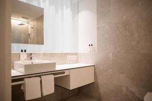 a bathroom with a sink and a mirror at Design Hotel Tyrol in Rablà