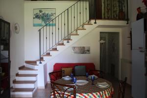 uma sala de jantar com uma mesa e uma escada em AGRITURISMO IL MONTOTO em Castiglione della Pescaia