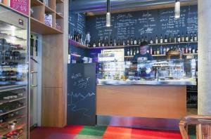 a bar with a person behind the counter in a restaurant at Quality Hosts Arlberg - Hotel ANTON in Sankt Anton am Arlberg