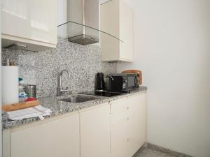 eine Küche mit weißen Schränken und einem Waschbecken in der Unterkunft Vienna Studio Apartments in Wien