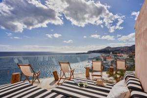 uma varanda com cadeiras e vista para o oceano em Okulus Madeira no Funchal