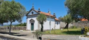 a small white church with a red roof at Casa Beira Rio in Viana do Castelo