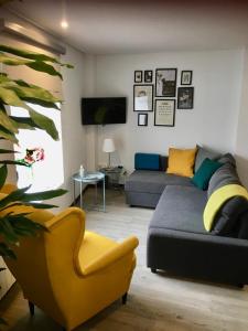 ein Wohnzimmer mit einem Sofa und einem Stuhl in der Unterkunft Casa Beira Rio in Viana do Castelo
