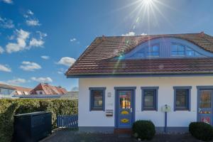 a white house with the sun in the sky at Bella Mare in Zingst