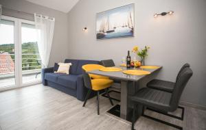 ein Wohnzimmer mit einem Tisch und einem blauen Sofa in der Unterkunft Apartment Vallissurda in Nečujam