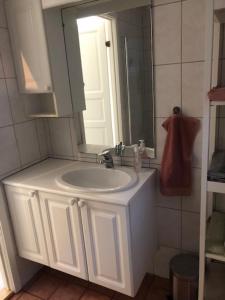 uma casa de banho com um lavatório branco e um espelho. em Koselig nyoppusset 3 roms leilighet med egen parkeringsplass i rolige omgivelse nær sjøen, 2 mil nord for Bergen sentrum. em Bergen
