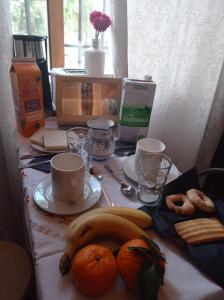 einen Tisch mit Orangen, Bananen und Tassen darauf in der Unterkunft Alojamiento rural Zona Bienestar in Aldeaquemada + 9 Fotos