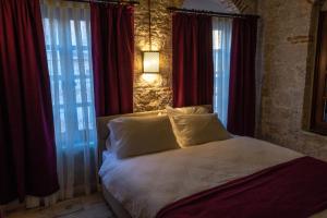Schlafzimmer mit einem großen Bett und roten Vorhängen in der Unterkunft Olea Leya in Ayvalık