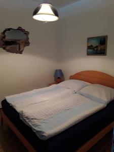 een bed in een slaapkamer met een licht aan de muur bij Residence Spighetta 2 in Torri del Benaco +34 foto's