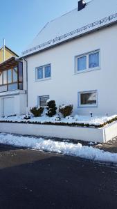 a white house with snow in front of it at Ferienwohnung Galina 1 in Rockenhausen