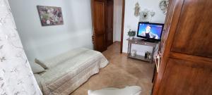 a small room with a bed and a television at Dolce shabby in Modica