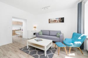 uma sala de estar com um sofá, uma mesa e cadeiras em Apartment and Rooms at Mostowa street em Poznań