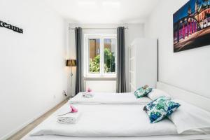 Duas camas num quarto branco com uma janela em Apartment and Rooms at Mostowa street em Poznań