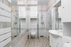 a white bathroom with a toilet and a sink at Apartment and Rooms at Mostowa street in Poznań