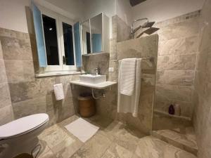 łazienka z białą toaletą i umywalką w obiekcie Magical villa, breathtaking views, large private garden and olive grove - in a cool village on the Umbria Tuscany Border w mieście Gioiella +37 zdjęć