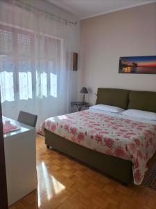 a bedroom with a bed with a red and white blanket at La Castellese in Aci Castello