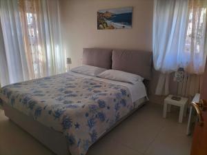 a bedroom with a bed with a blue and white comforter at La Castellese in Aci Castello