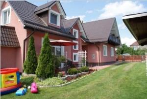 a house with a play equipment in the yard at Villa Marta in Augustów