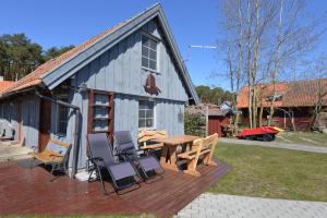 een terras met stoelen en een tafel en een gebouw bij Vasarnamis Preiloje pas Žilviną in Neringa