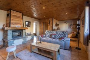 un soggiorno con divano e camino di Le Brec a Barcelonnette