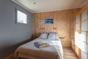 una camera da letto con un letto in una stanza con pareti in legno di Le Brec a Barcelonnette