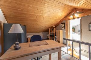 una stanza con un soffitto in legno e un tavolo con una lampada di Le Brec a Barcelonnette