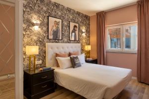 a bedroom with a white bed and a wall with pictures at Hotel Made Inn in Portimão